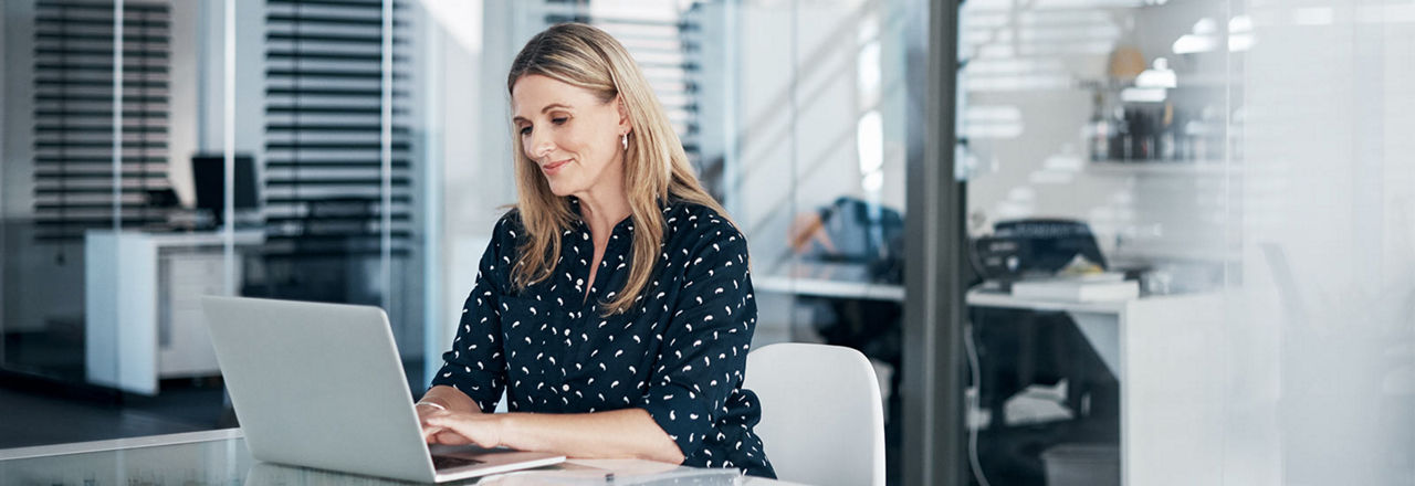Frau sitzt im Büro am Laptop