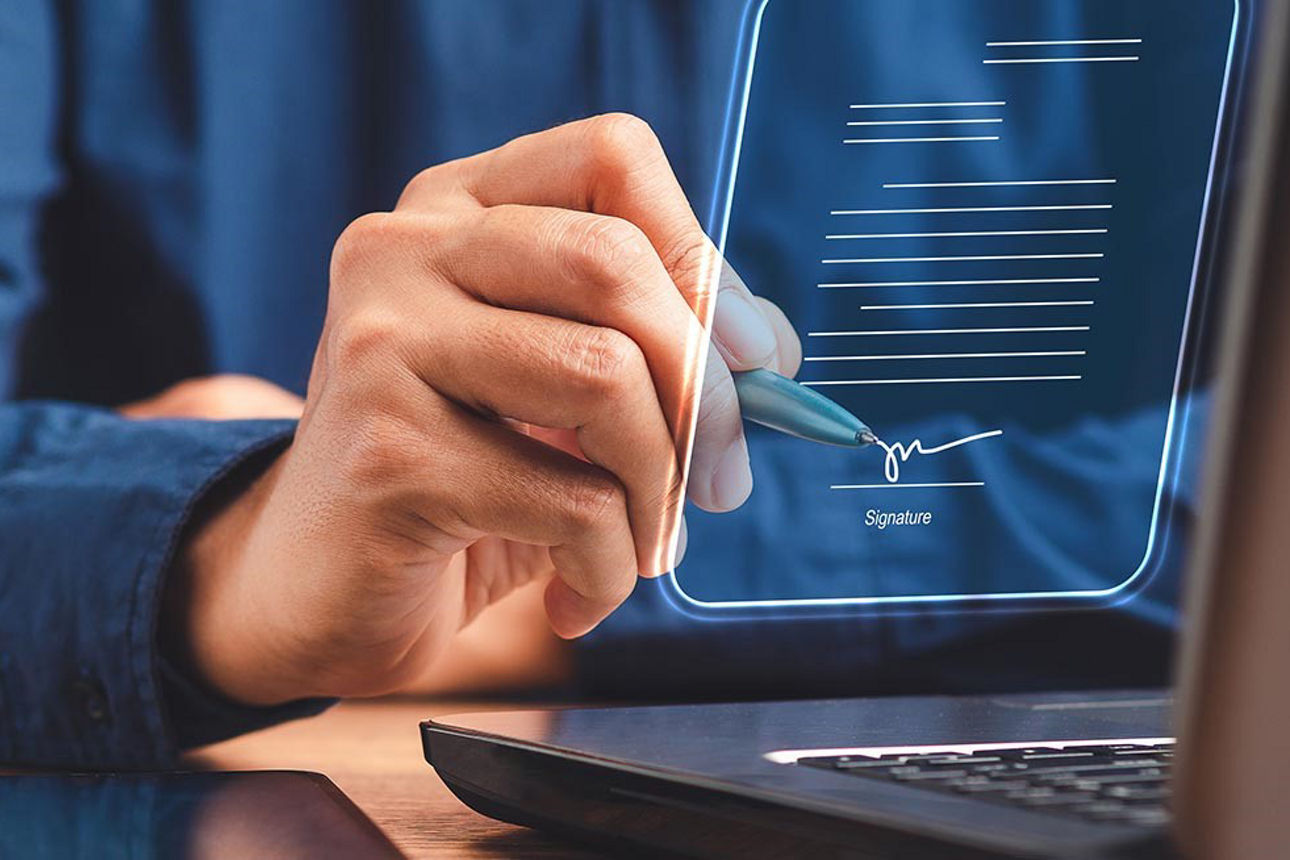 Herr im blauen Hemd unterschreibt digital auf virtuellem Display