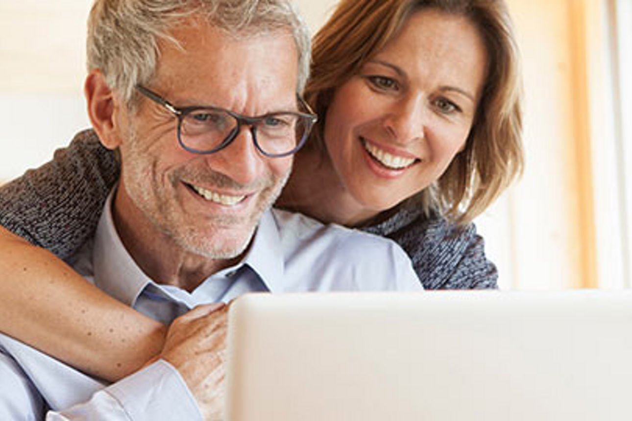 Ein Mann und eine Frau sitzen vor einem Laptop