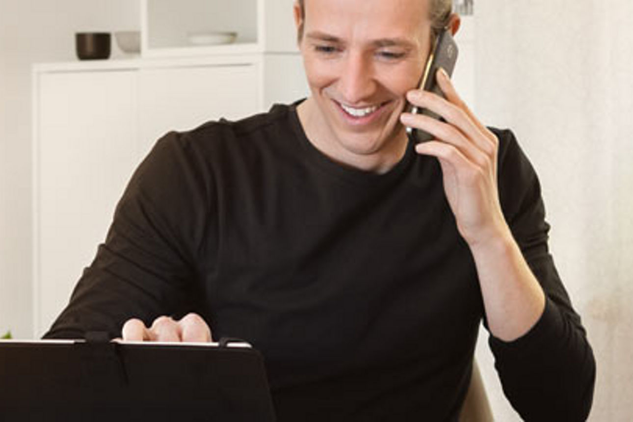 Ein Mann hilft einem Kunden am Telefon