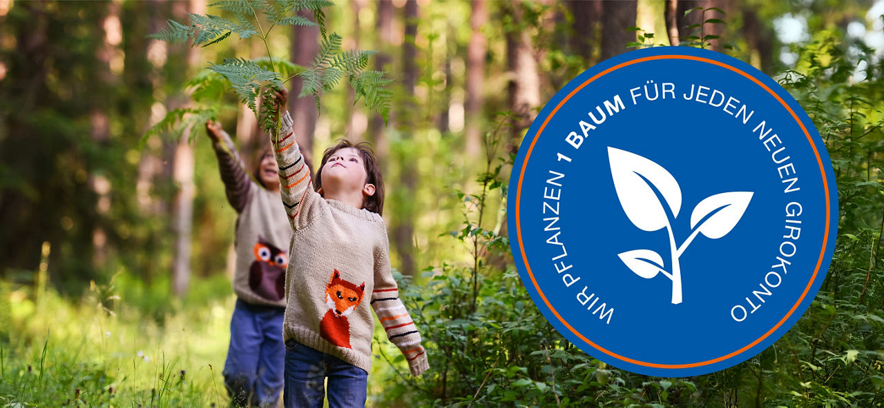Zwei Kinder spielen im Wald und strecken sich nach einem Baumzweig