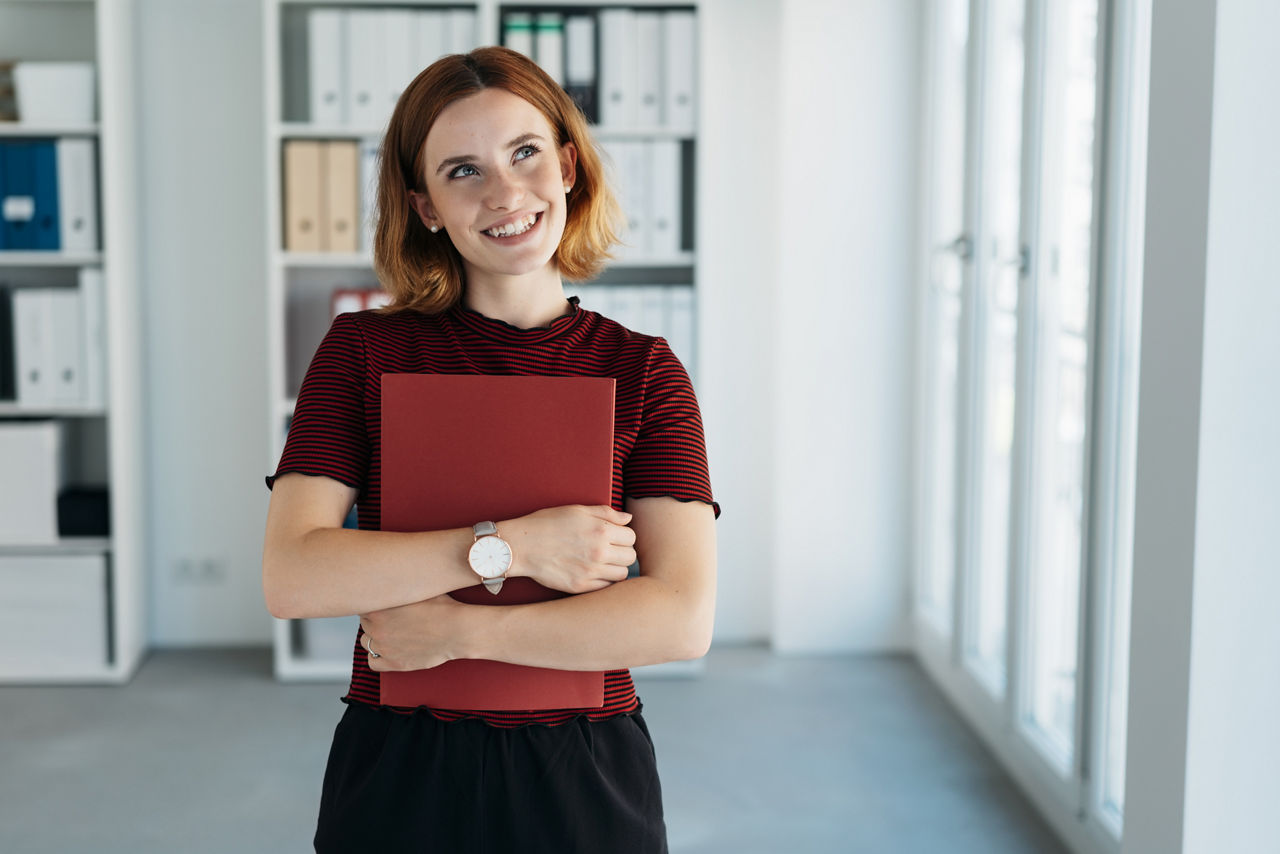 Junge Frau hält eine rote Mappe