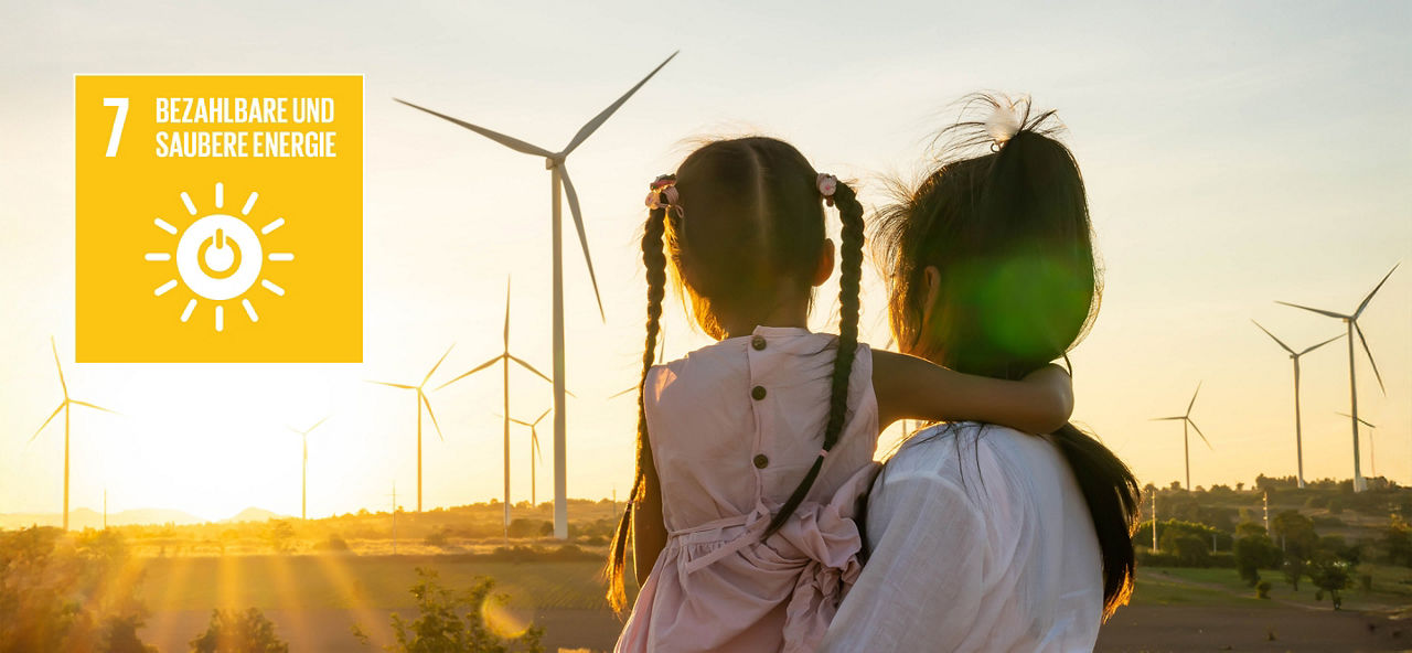 Mutter und Tocher blicken auf ein Feld mit Windrädern, daneben Icon "Bezahlbare und Saubere Energie"