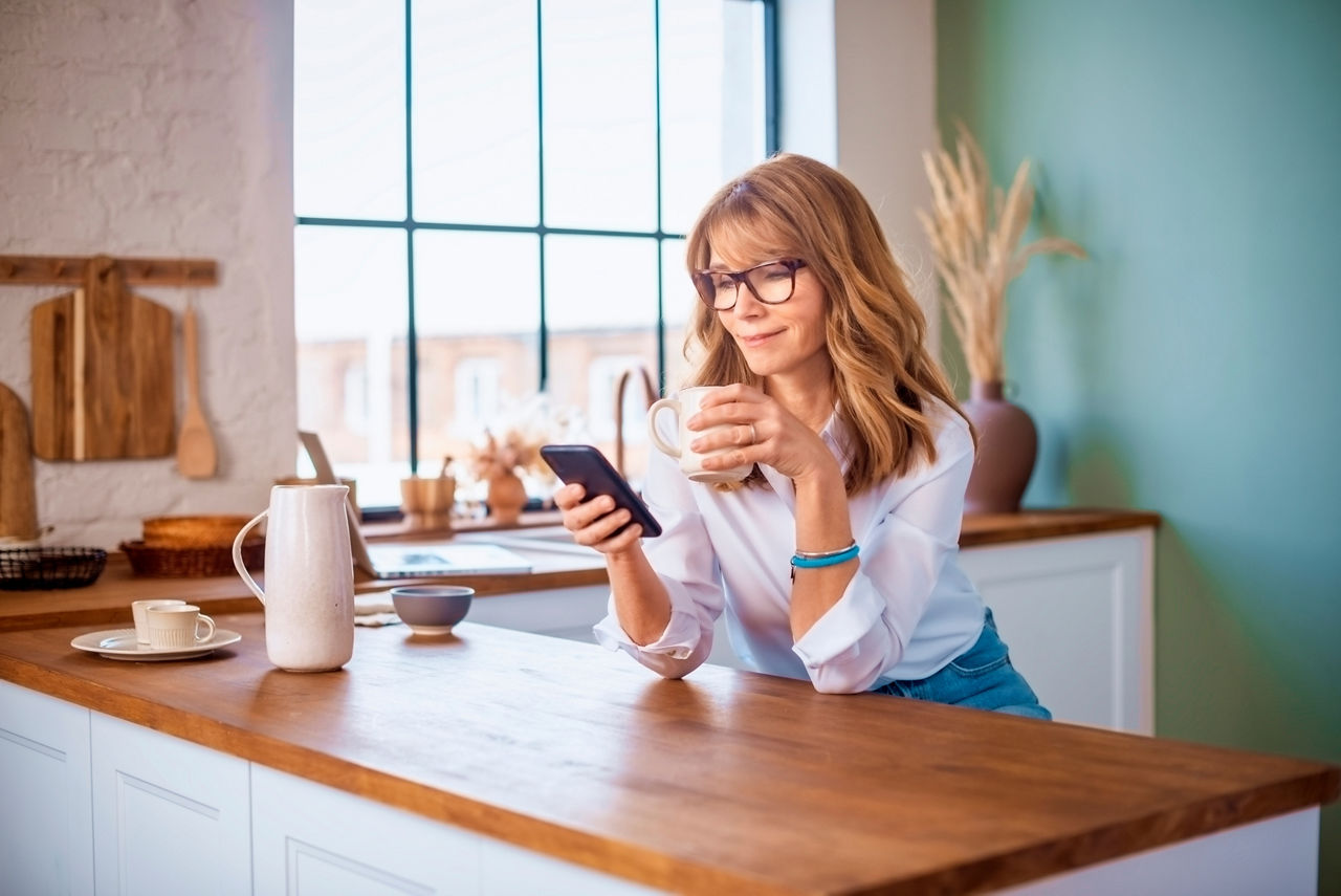 Junge Frau mit einem Smartphone in der Hand schaut auf die Banking App