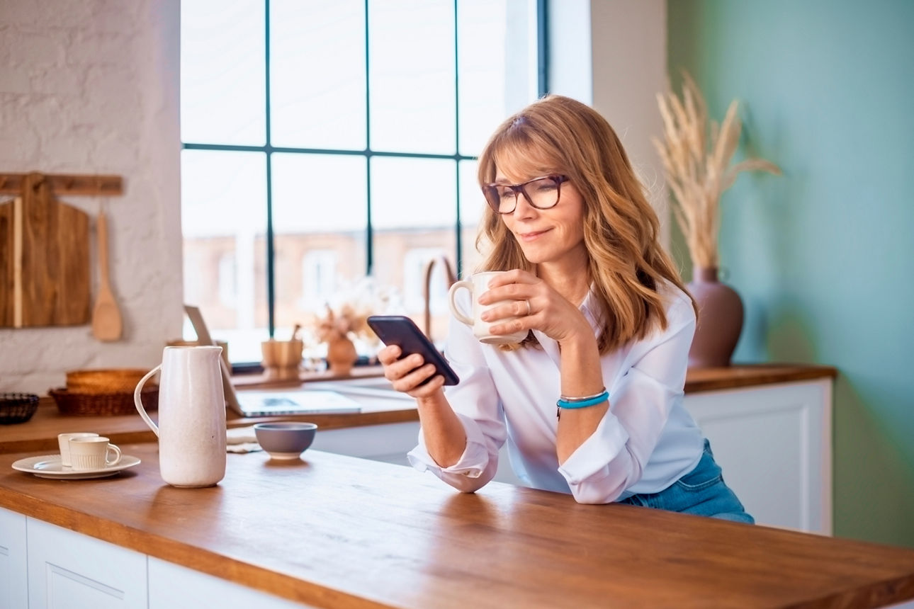 Junge Frau mit einem Smartphone in der Hand schaut auf die Banking App
