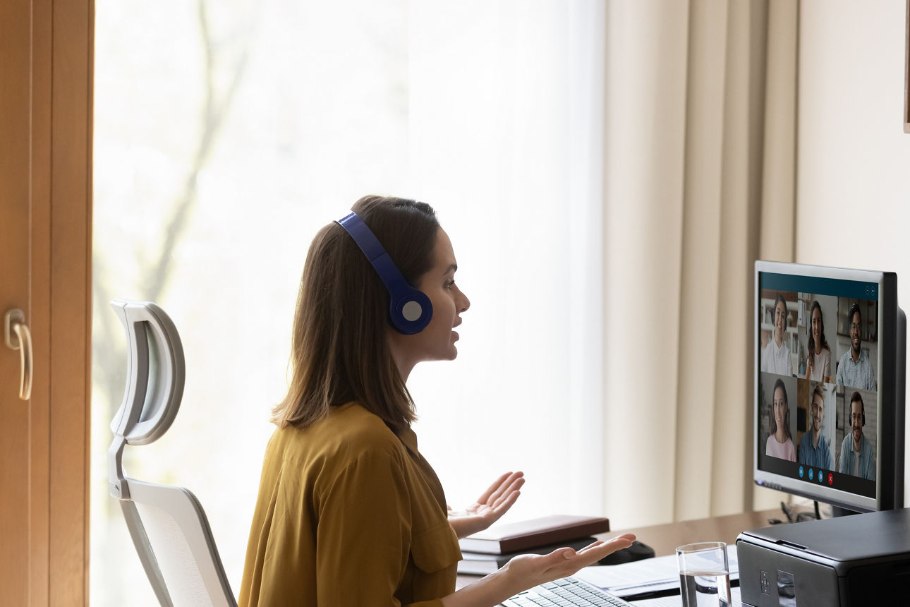 eine Frau am Schreibtisch, die in einer Videokonferenz ist 