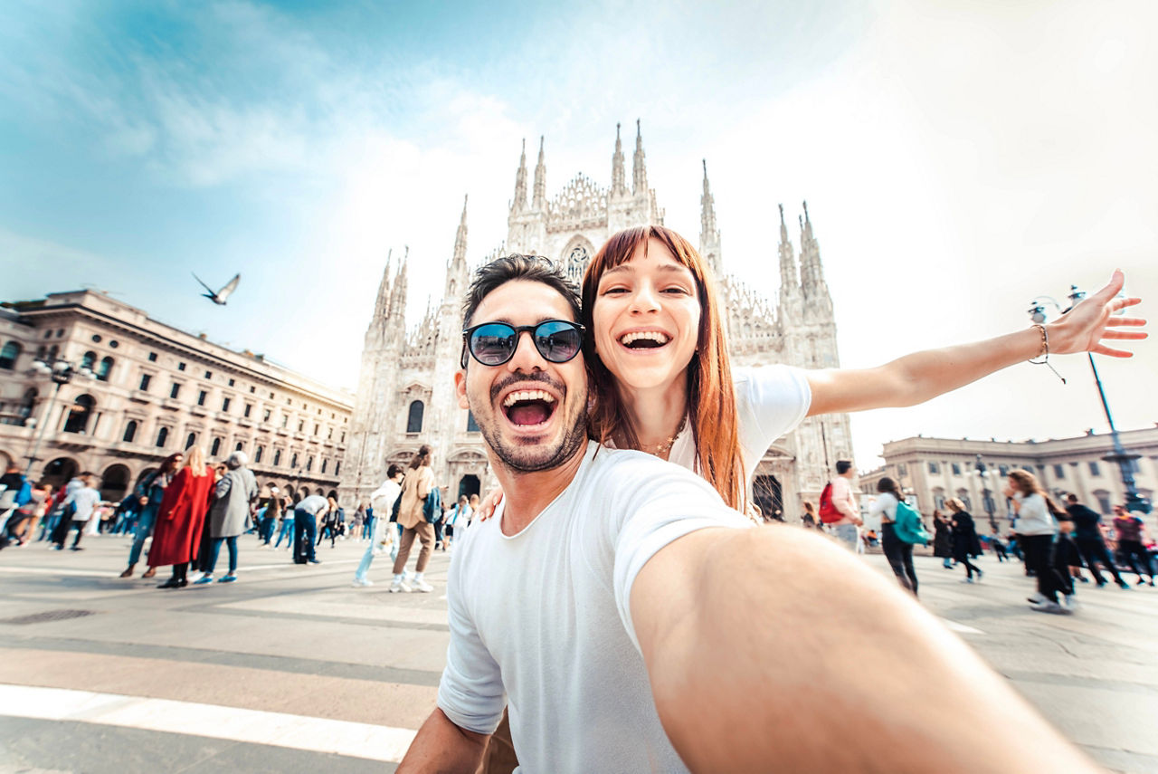 Zwei junge Menschen stehend vor eine Kirche und machen ein Selfie