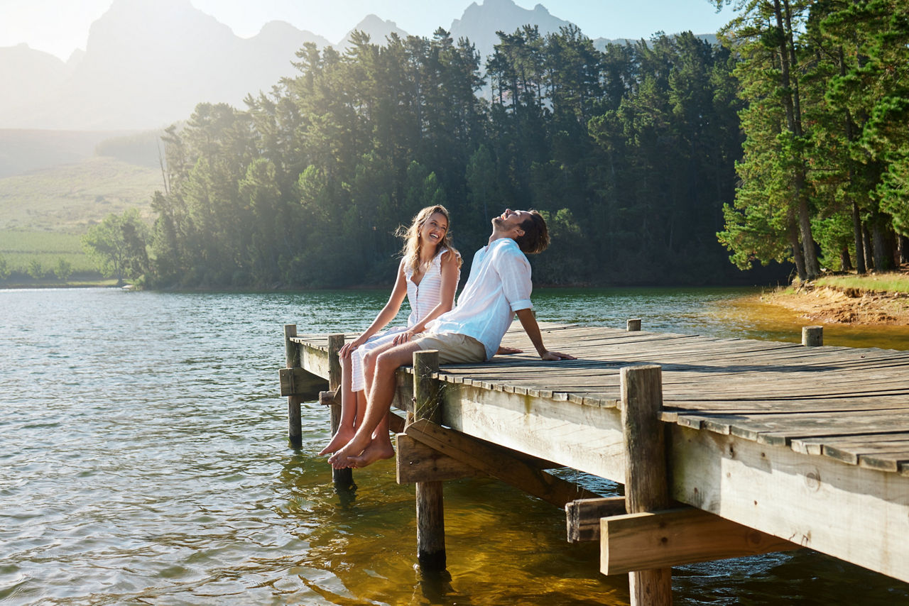 Mann und Frau sitzen auf einem Steg am See