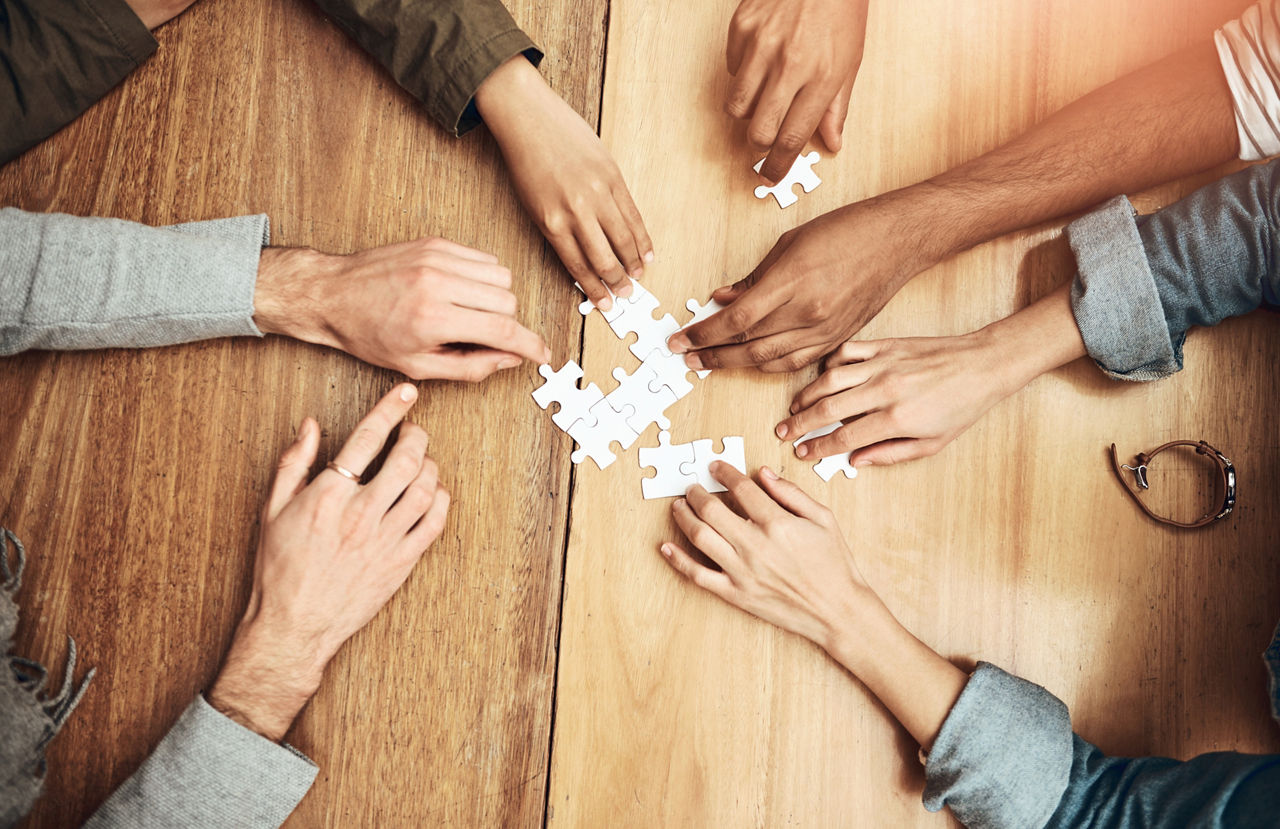 Viele Hände puzzeln