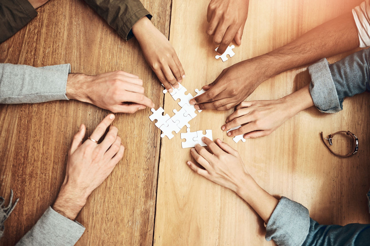 Viele Hände puzzeln