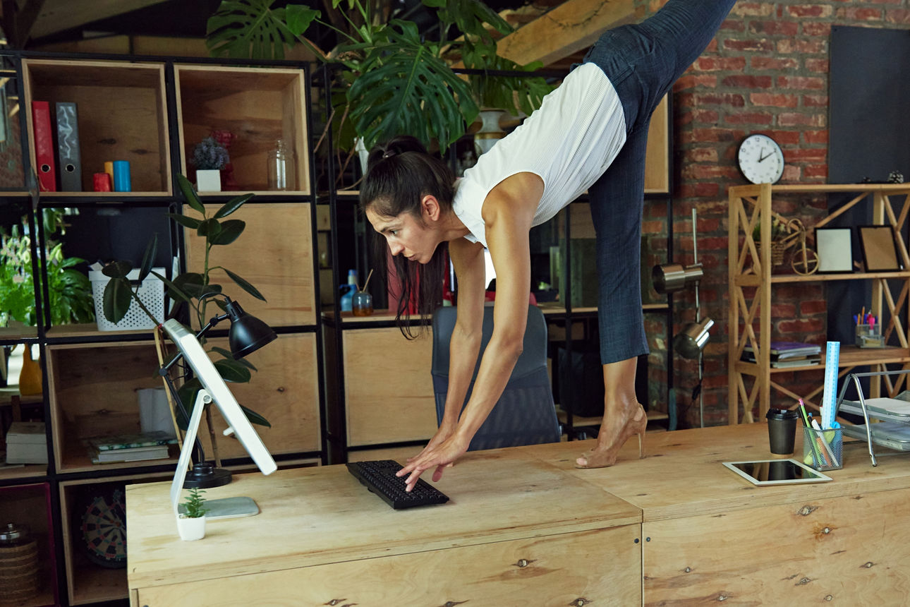 Frau in Yogapose am Computer arbeiten