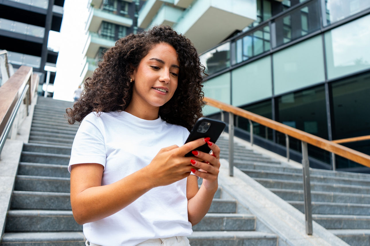 Junge Damen mit dem iPhone in der Hand auf einer Treppe