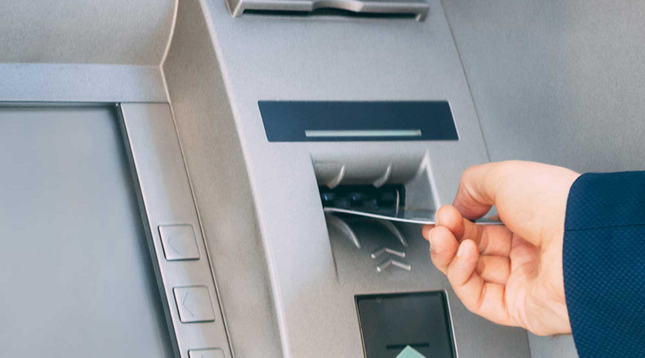 Eine Girocard wird in einen Geldautomaten gesteckt