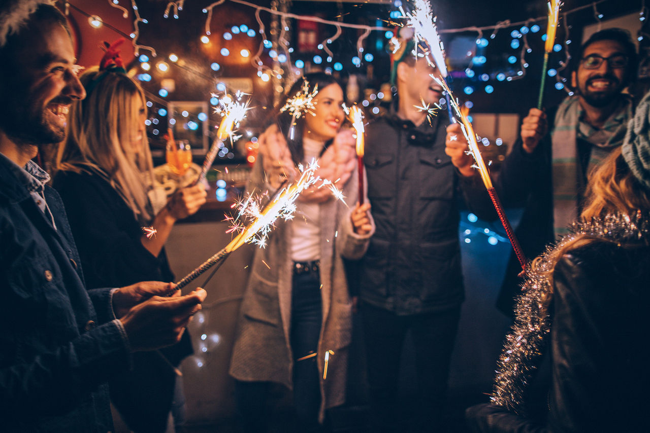 Menschen stehen mit Wunderkerzen zusammen.