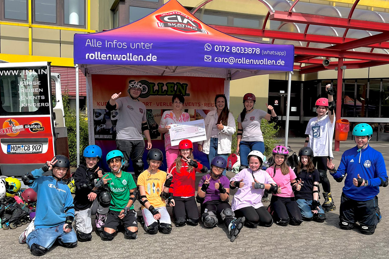 Viele Kinder in Skatekleidung, vor einem Pavillion