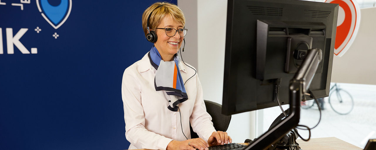 Blonde Beraterin mit Headset im Kundengespräch