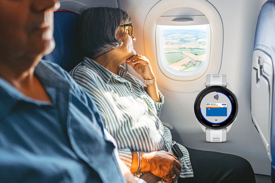 Eine Frau schaut im Flugzeug aus dem Fenster, daneben eine Abbildung einer Smartwatch