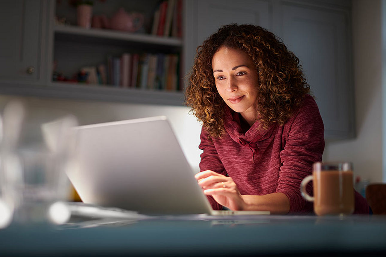 Eine Frau sitzt an Ihrem Laptop