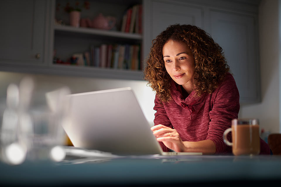 Frau arbeitet zuhause an einem Notebook