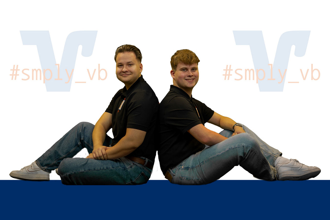 Zwei Personen, die in einer professionellen Umgebung Rücken an Rücken sitzen und nach vorne schauen.