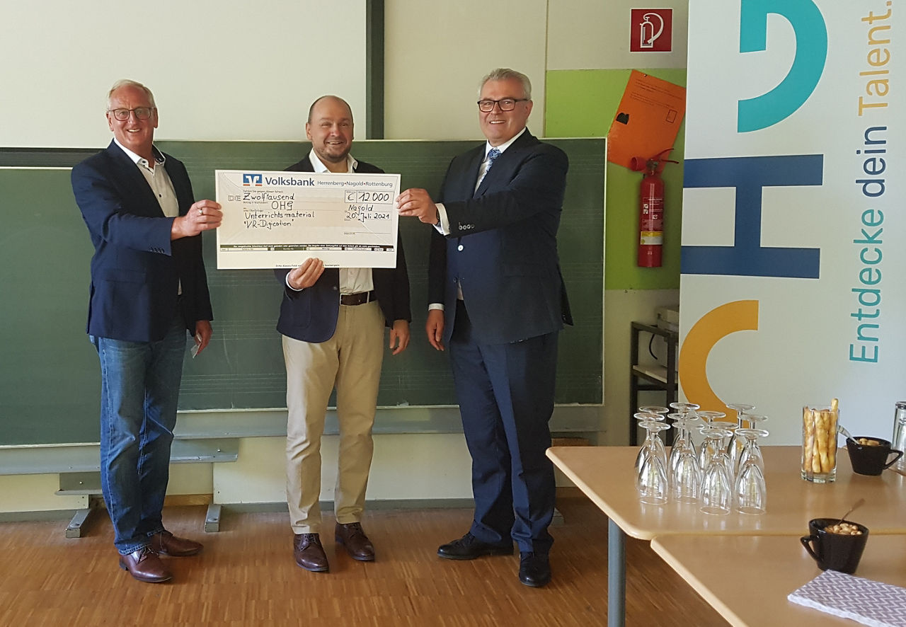 Vorstand der Volksbank (rechts) übergibt Spendenscheck an OHG