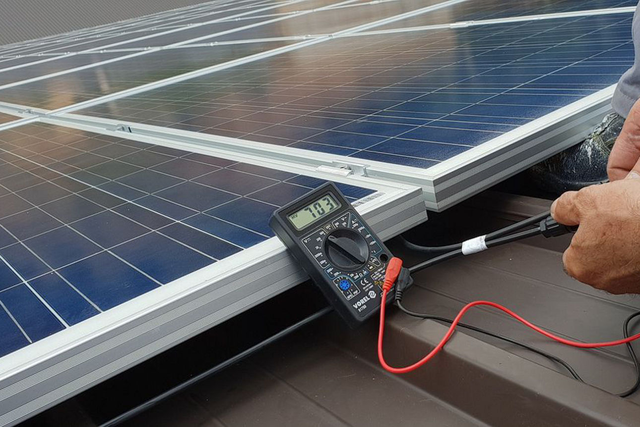 Techniker bei der Messung eines Solarpanels