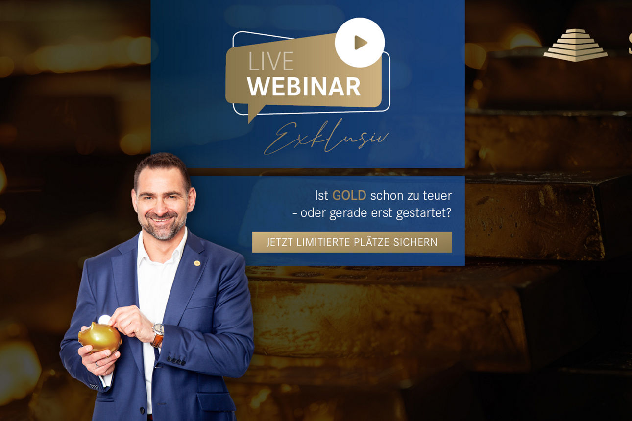 Ein Mann mit einem goldenen Sparscwein steht vor einer Wand mit Goldbarren.