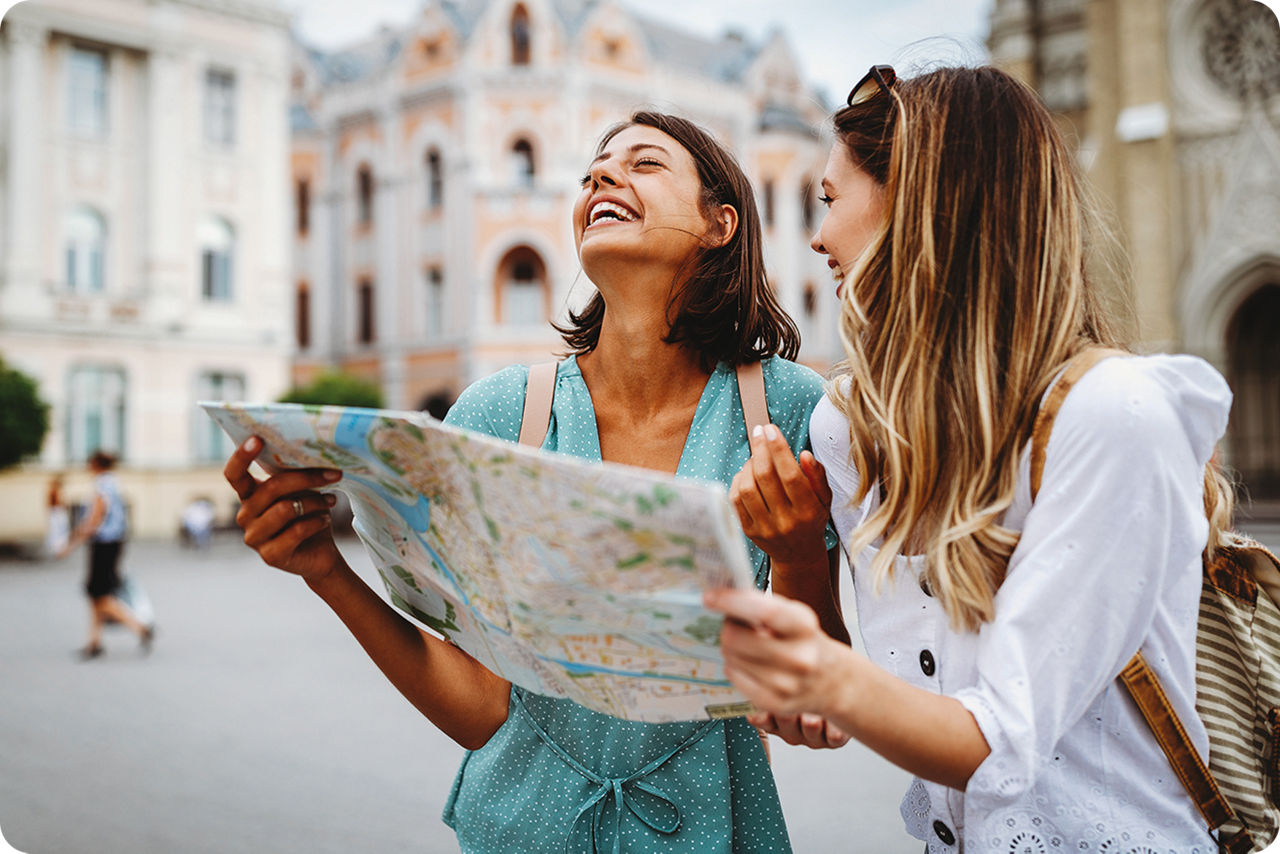 Zwei jungen Frauen machen Sightseeing und haben eine Stadtplan in der Hand
