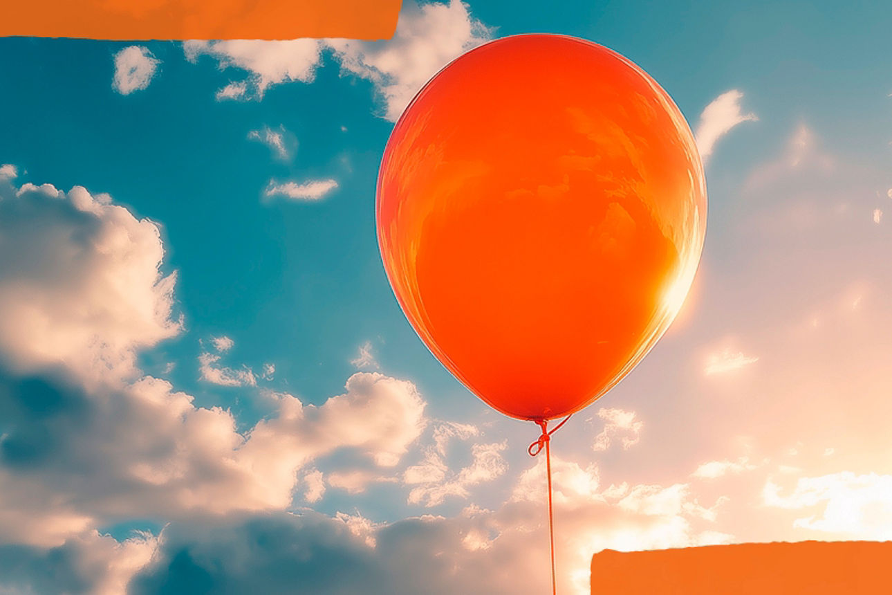 Ein schwebender orangefarbener Luftballon