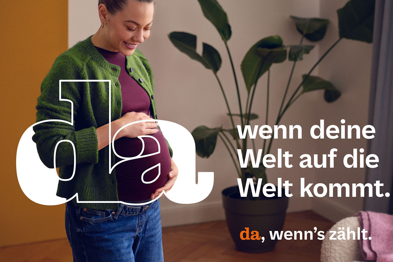 Eine Frau in freudiger Erwartung hält sich lächelnd den Bauch