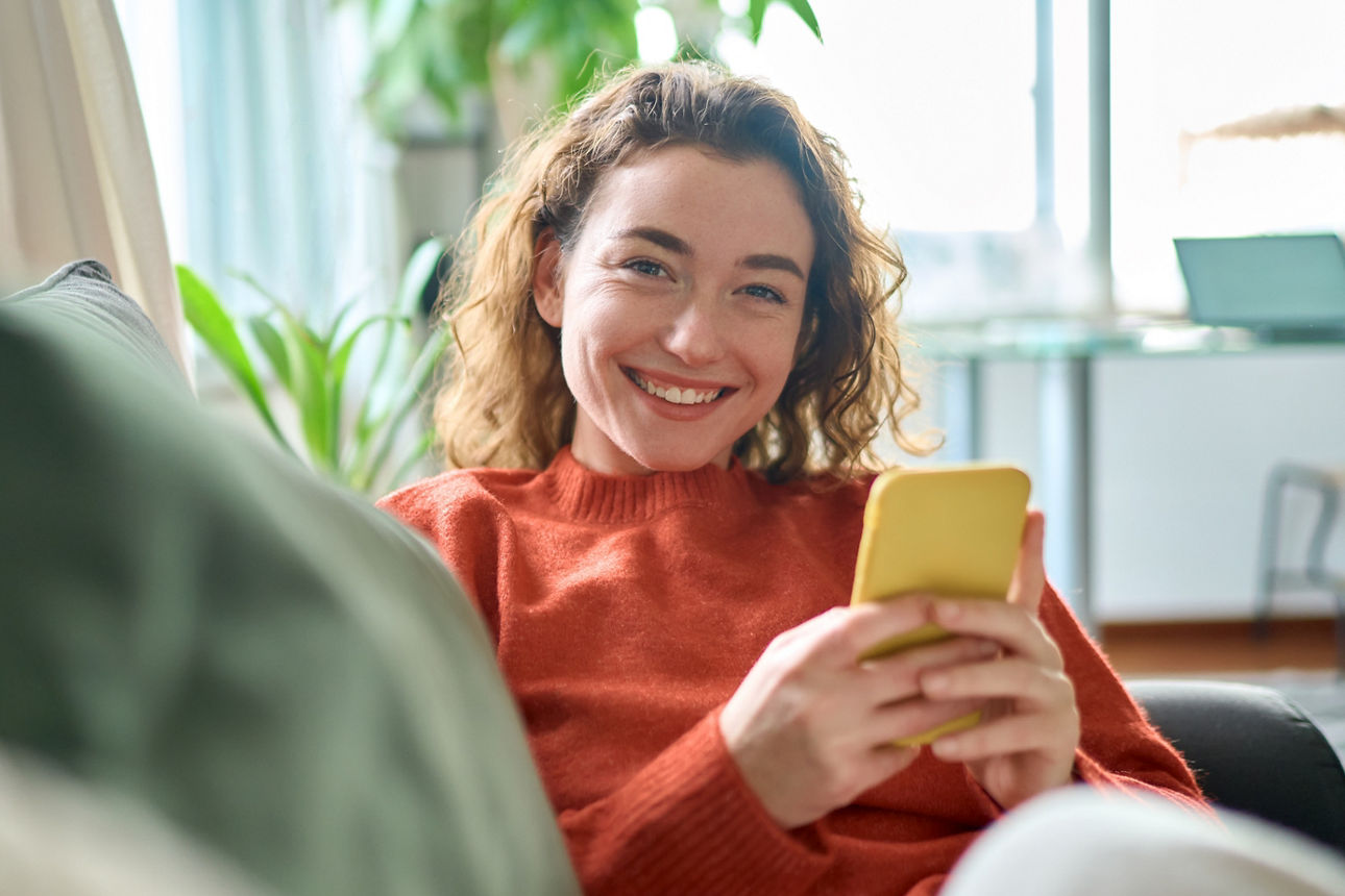 Kundin mit Smartphone und der Sparda BankingApp beim mobilen Online-Banking