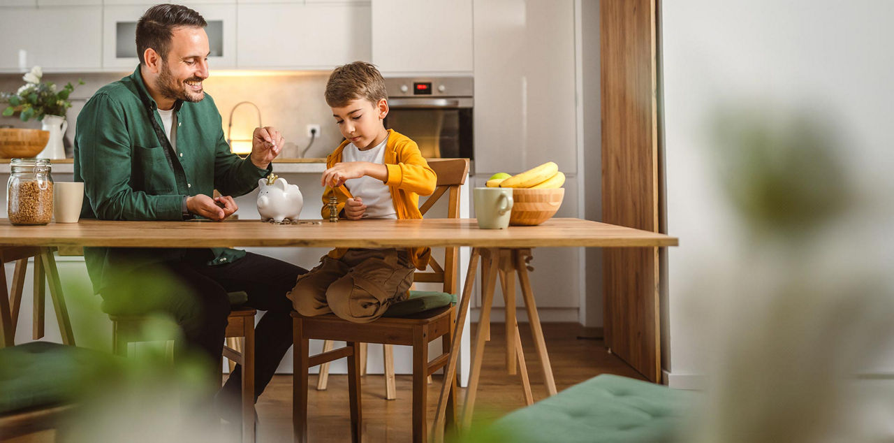Vater zeigt seinem Sohn wie man Geld spart