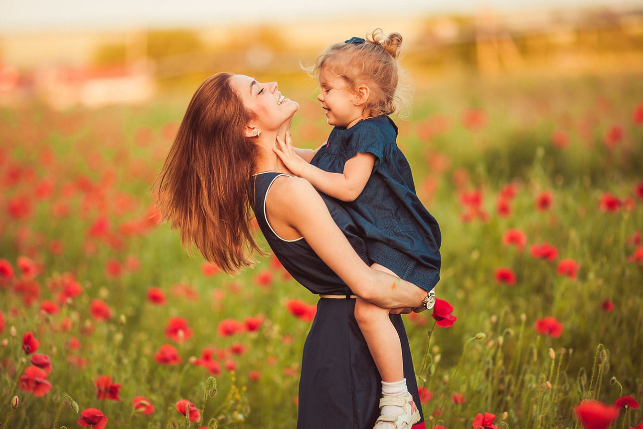 Frau mit Kind im Blumenfeld