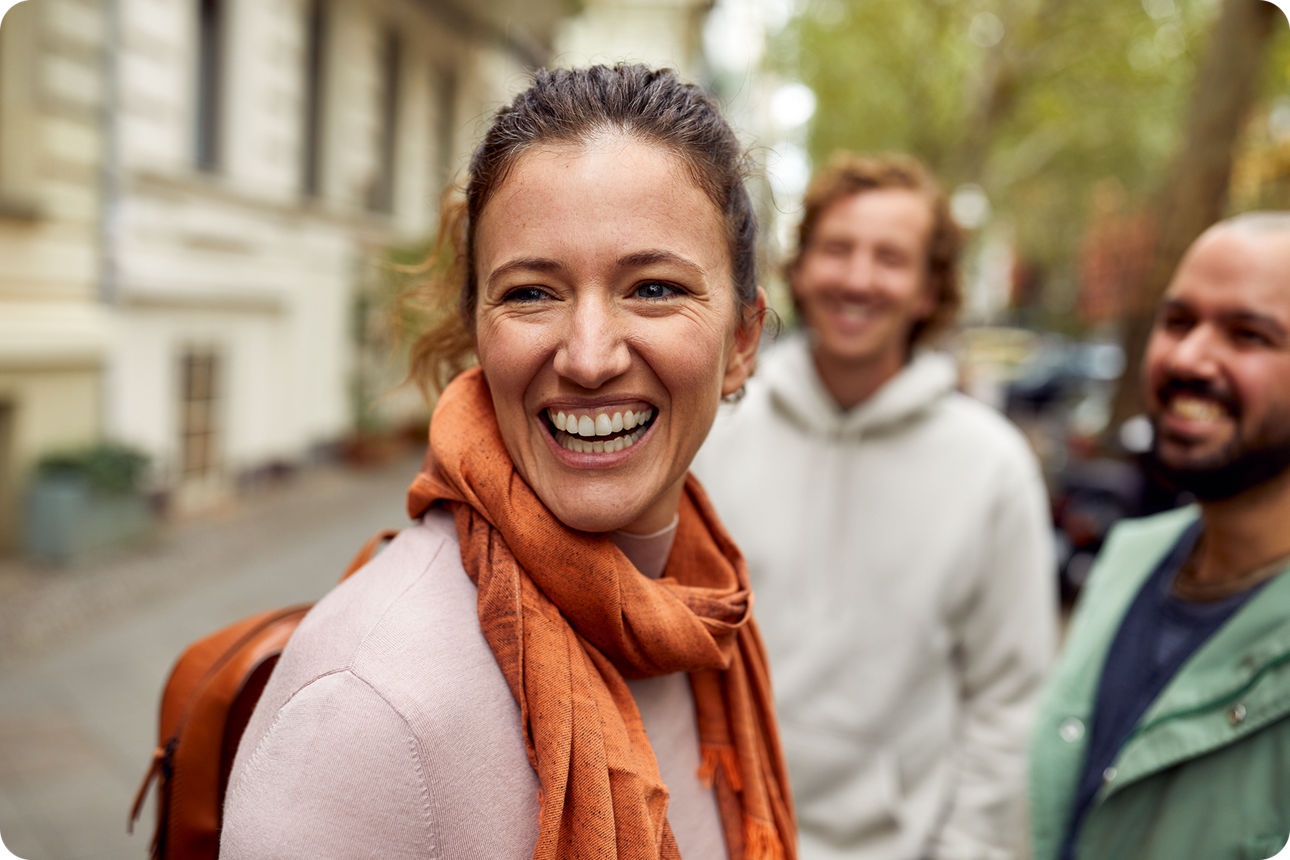 Eine Frau steht mit ihren Freunden auf der Straße und lacht