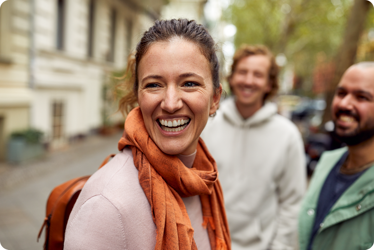 Eine Frau steht mit ihren Freunden auf der Straße und lacht