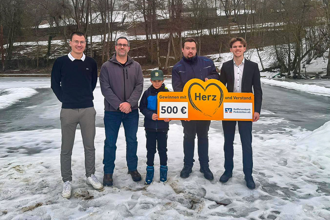 Gruppenfoto mit mehreren Erwachsenen vor einem Teich