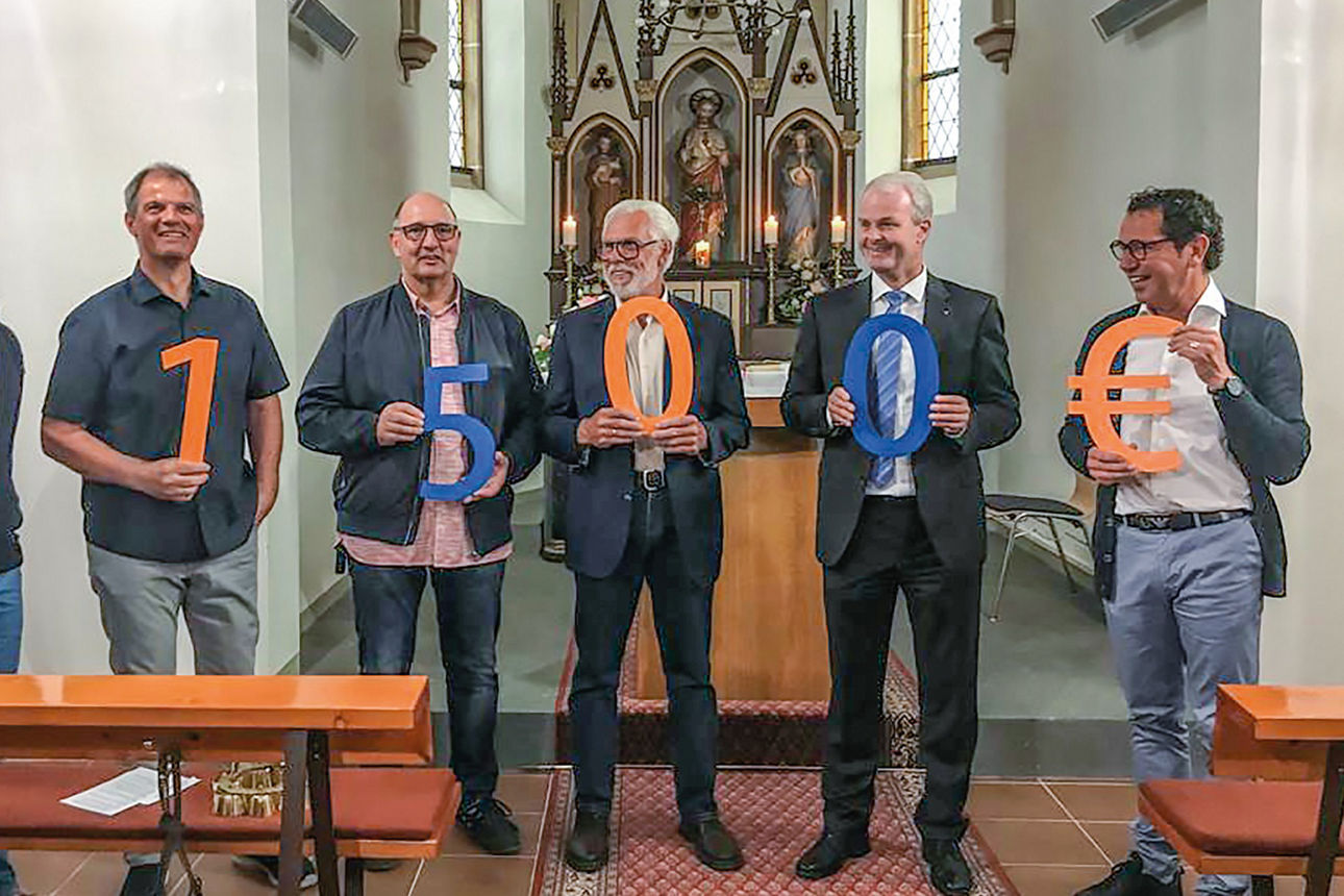 Mitglieder des Kapellenerhaltungsvereins und Mitarbeiter der Raiffeisenbank stehen in der Kapelle Notscheid