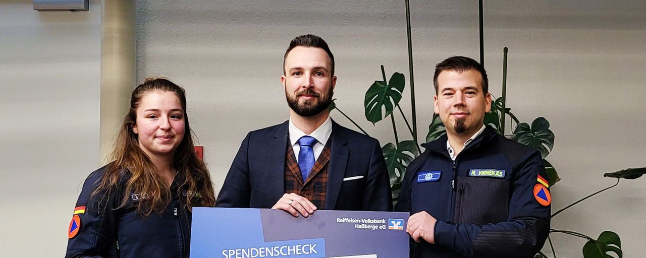 Tobias Müller übergibt einen Spendenscheck an das THW OV Haßfurt