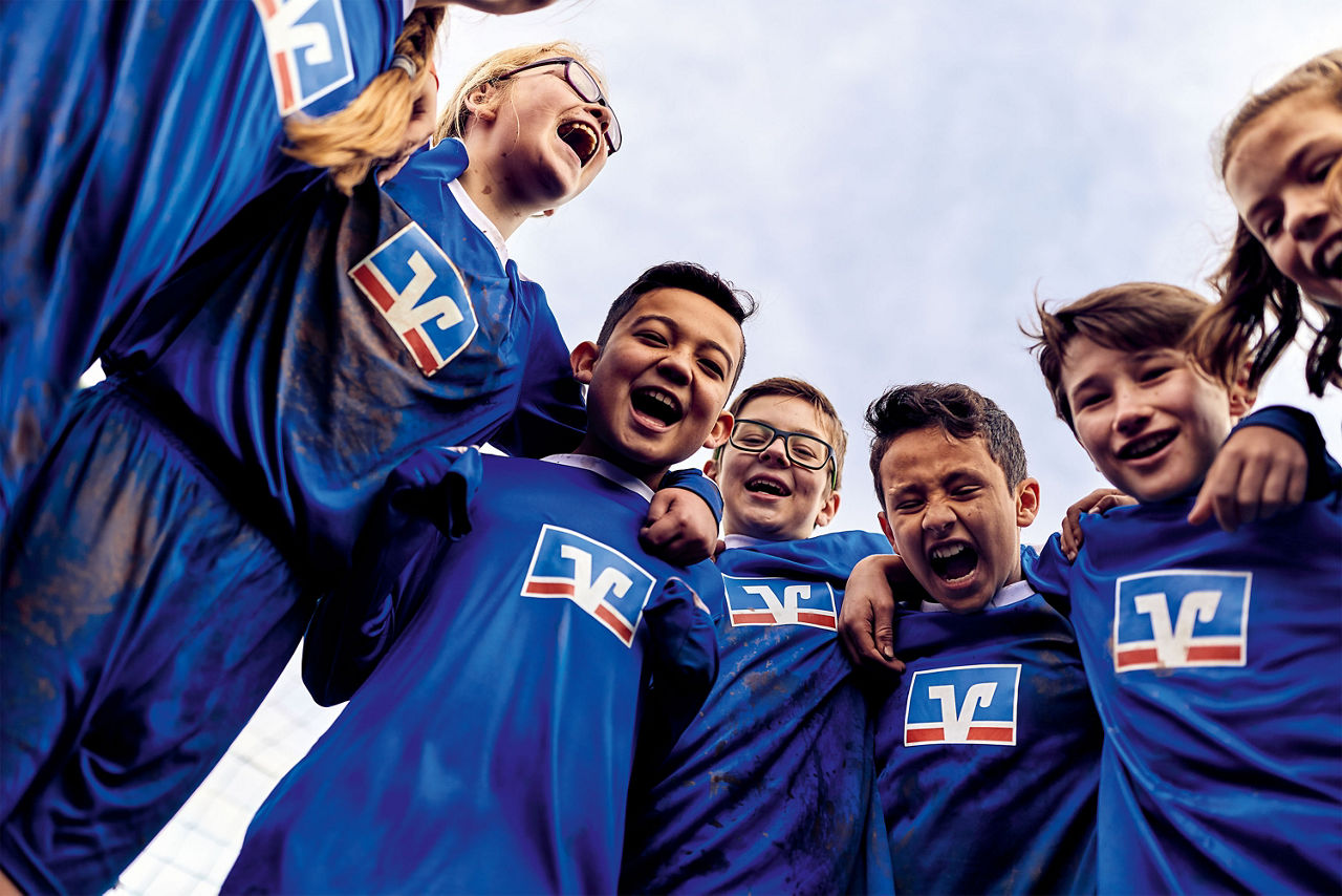 Sich freuende Kinder einer Fußballmannschaft stehen im Kreis