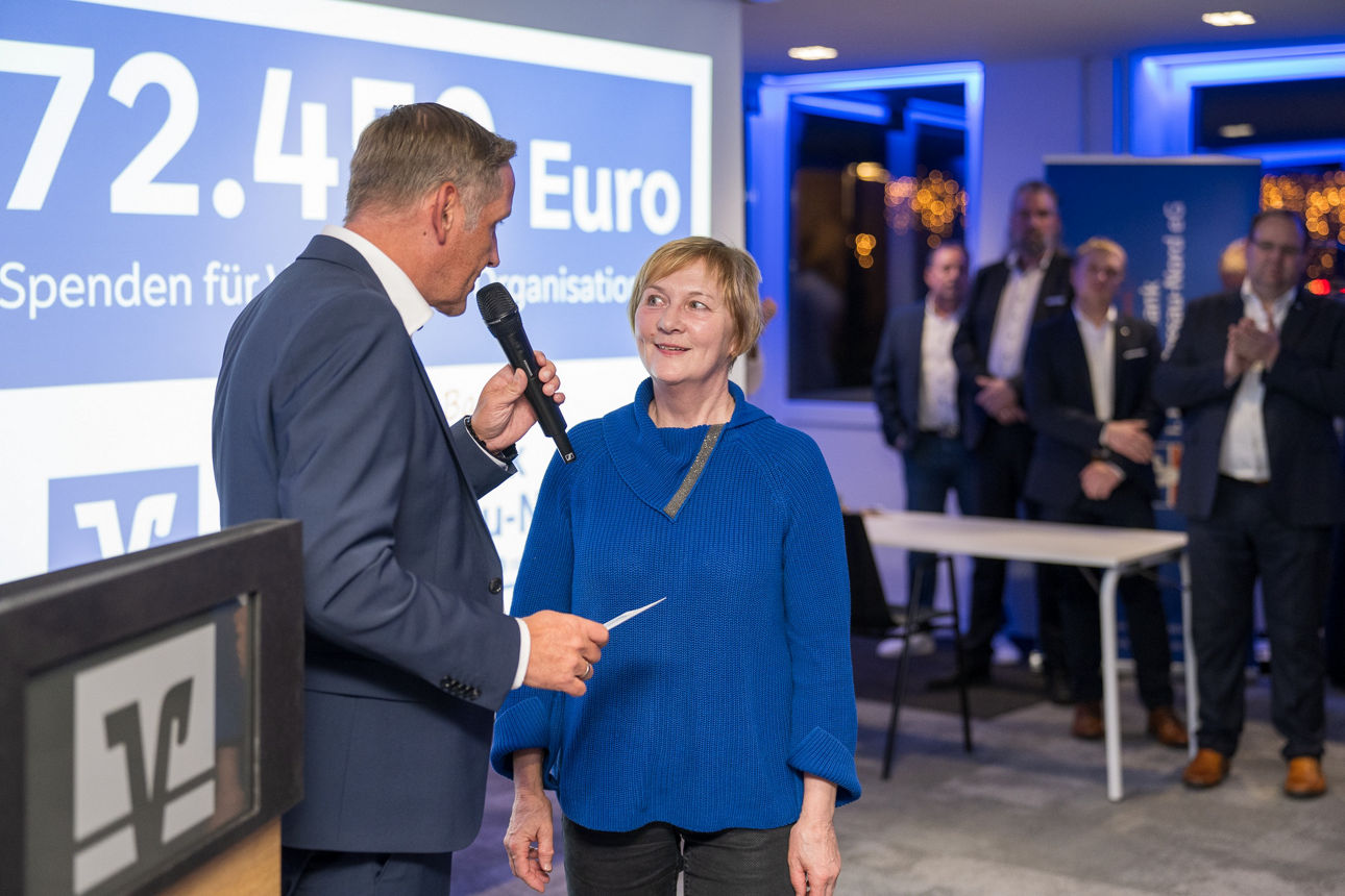 Ein Mann mit einem Mikrofon wärend er einer Frau redet.