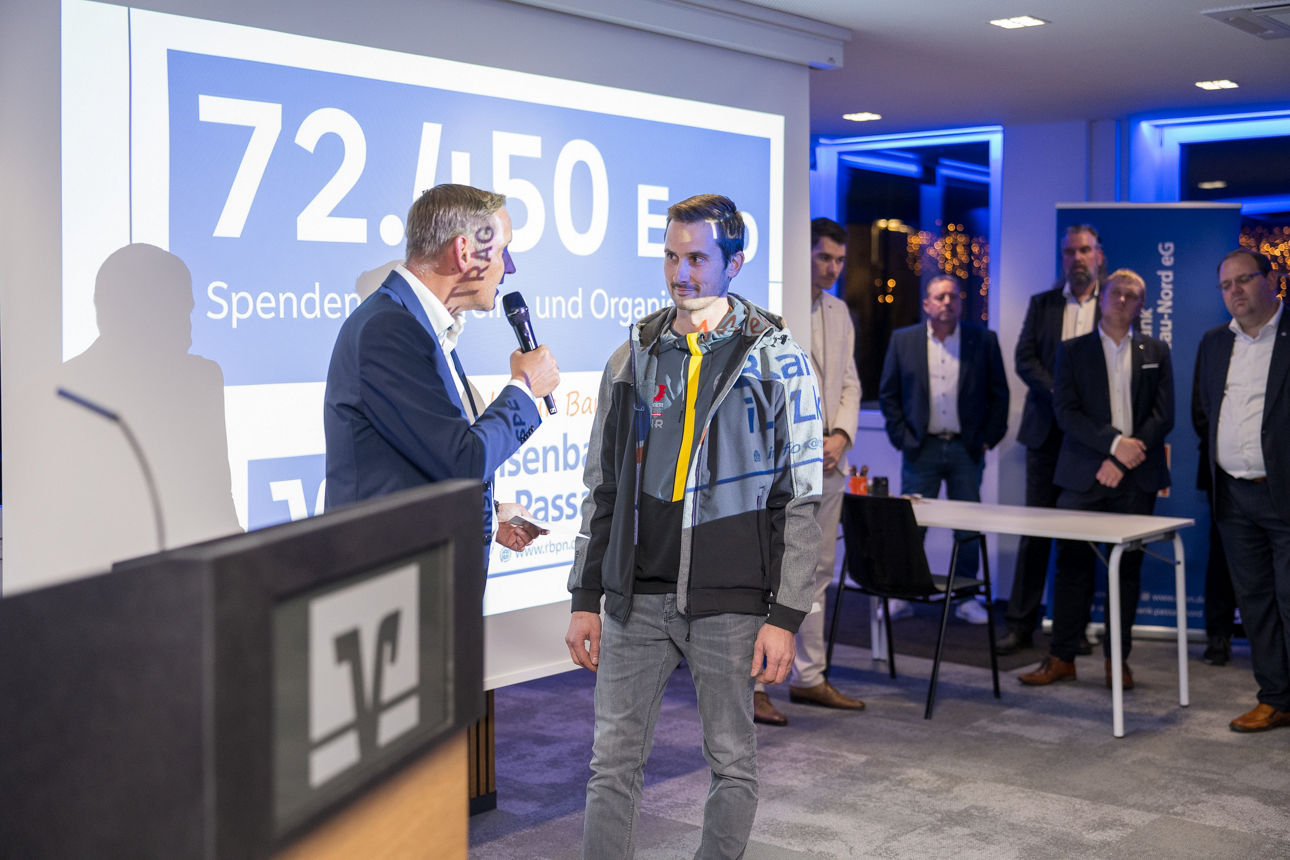 Ein Mann mit einem Mikrofon wärend er einem Mann redet.