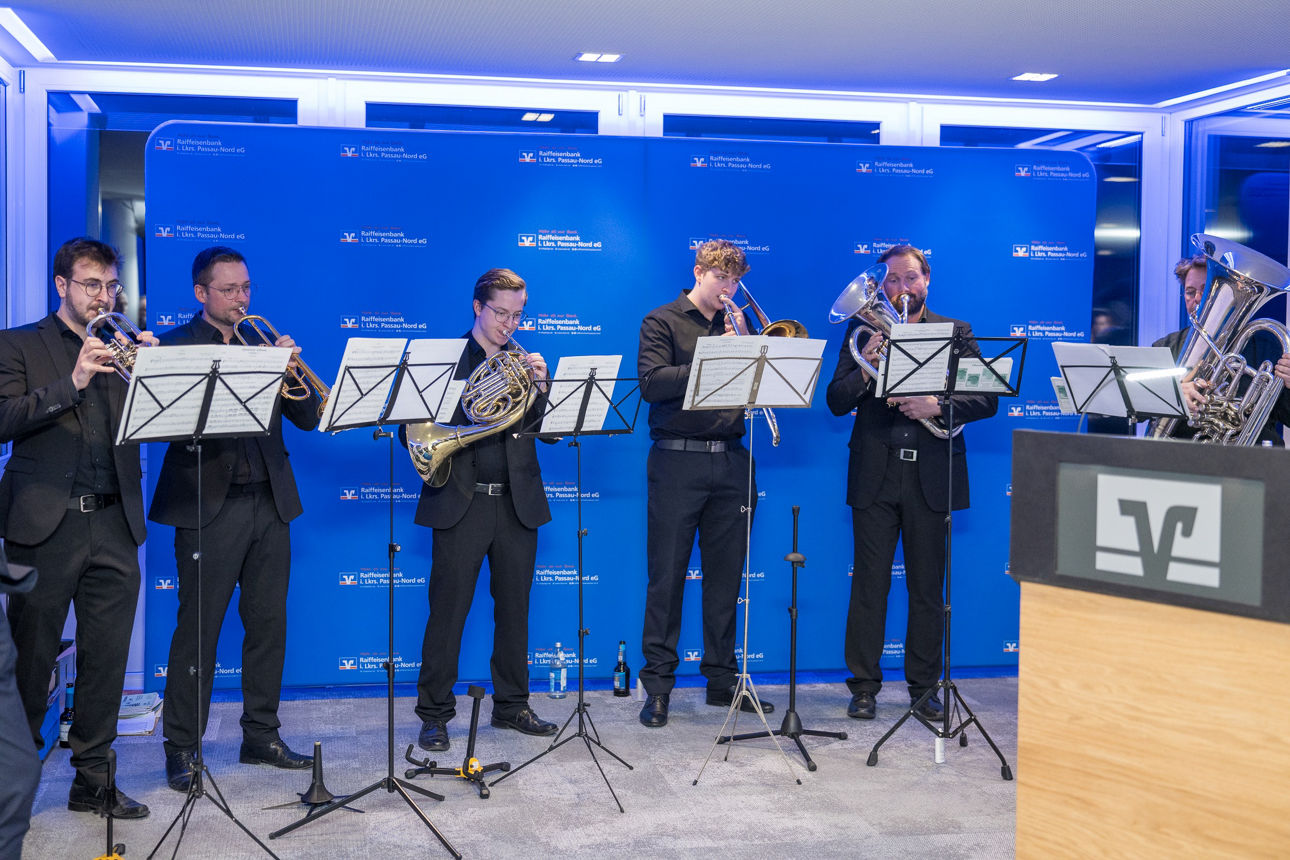 Eine Band auf der Bühne wärend sie die Menschen unterhalten. 