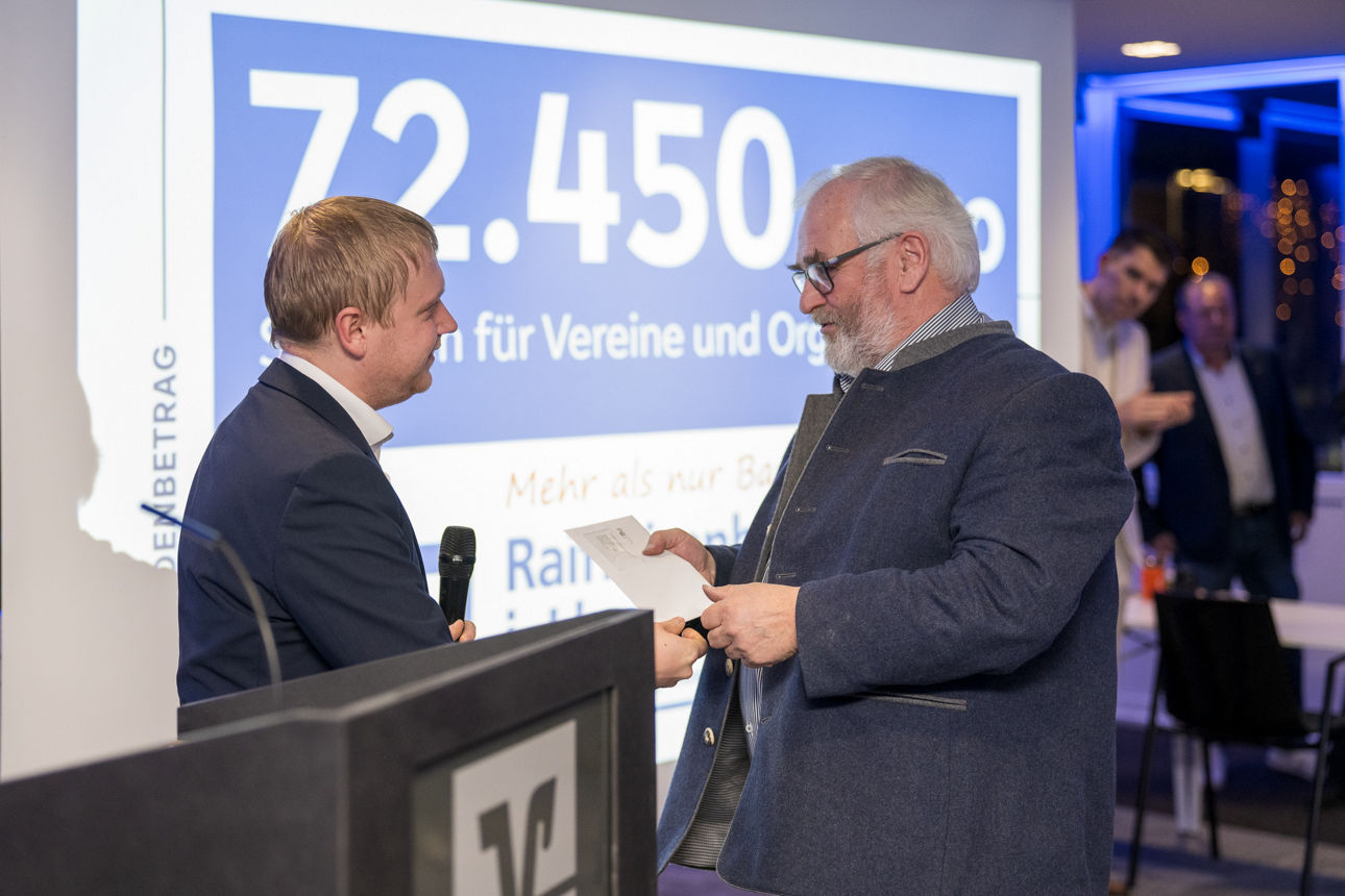 Ein Mann mit einem Mikrofon wärend er einem Mann redet.