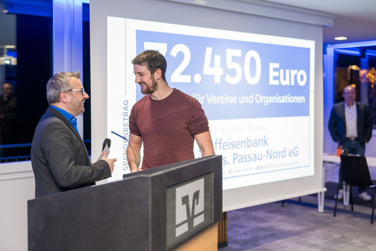 Ein Mann mit einem Mikrofon wärend er einem Mann redet.