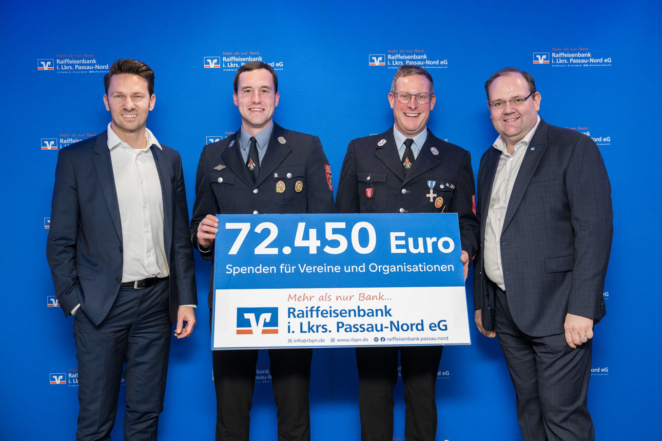 Der Scheck über 72.450 Euro und vier Herren im Hintergrund. 