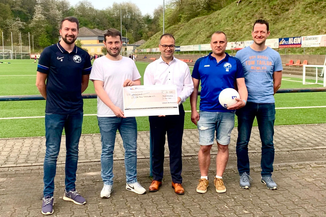 Fußballvereinigung erhält Spende.  Ein symbolischer Moment der Unterstützung für den Sport.