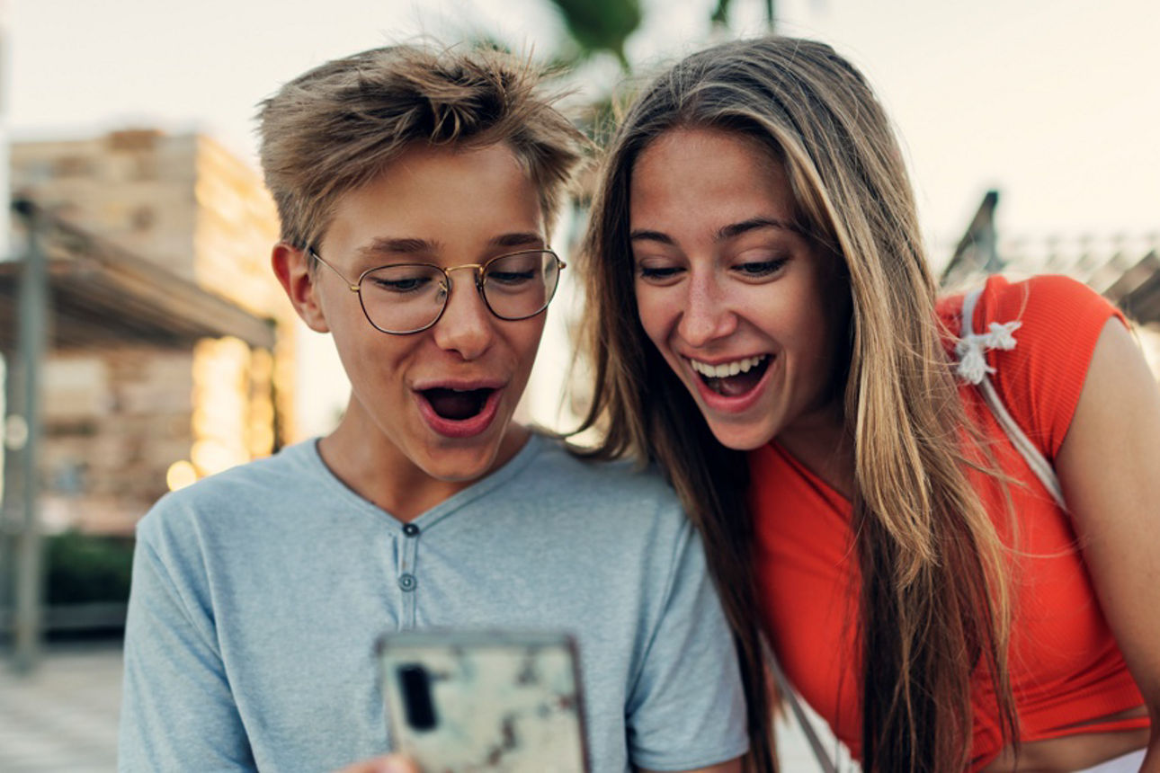 Zwei Jugendliche schauen auf ein Smartphone
