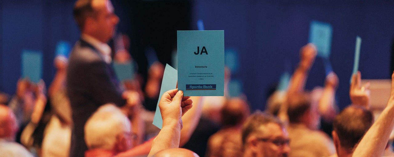 Person hält einen Stimmzettel mit "JA" hoch