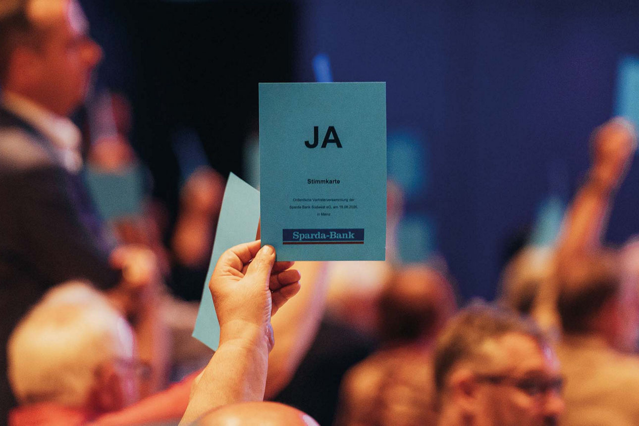 Person hält einen Stimmzettel mit "JA" hoch