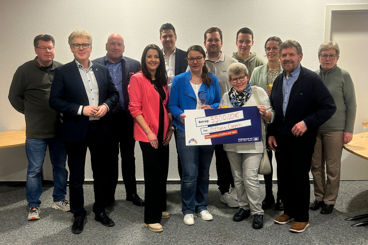 Eine Personengruppe der Stiftung erhält einen Check